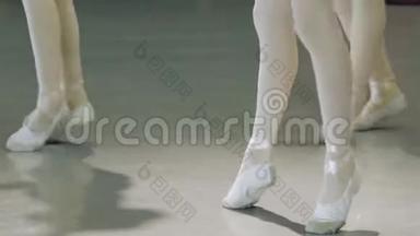 芭蕾。 在芭蕾训练中，一个穿白色芭蕾舞鞋的女孩`了她的腿。 古典舞蹈元素...